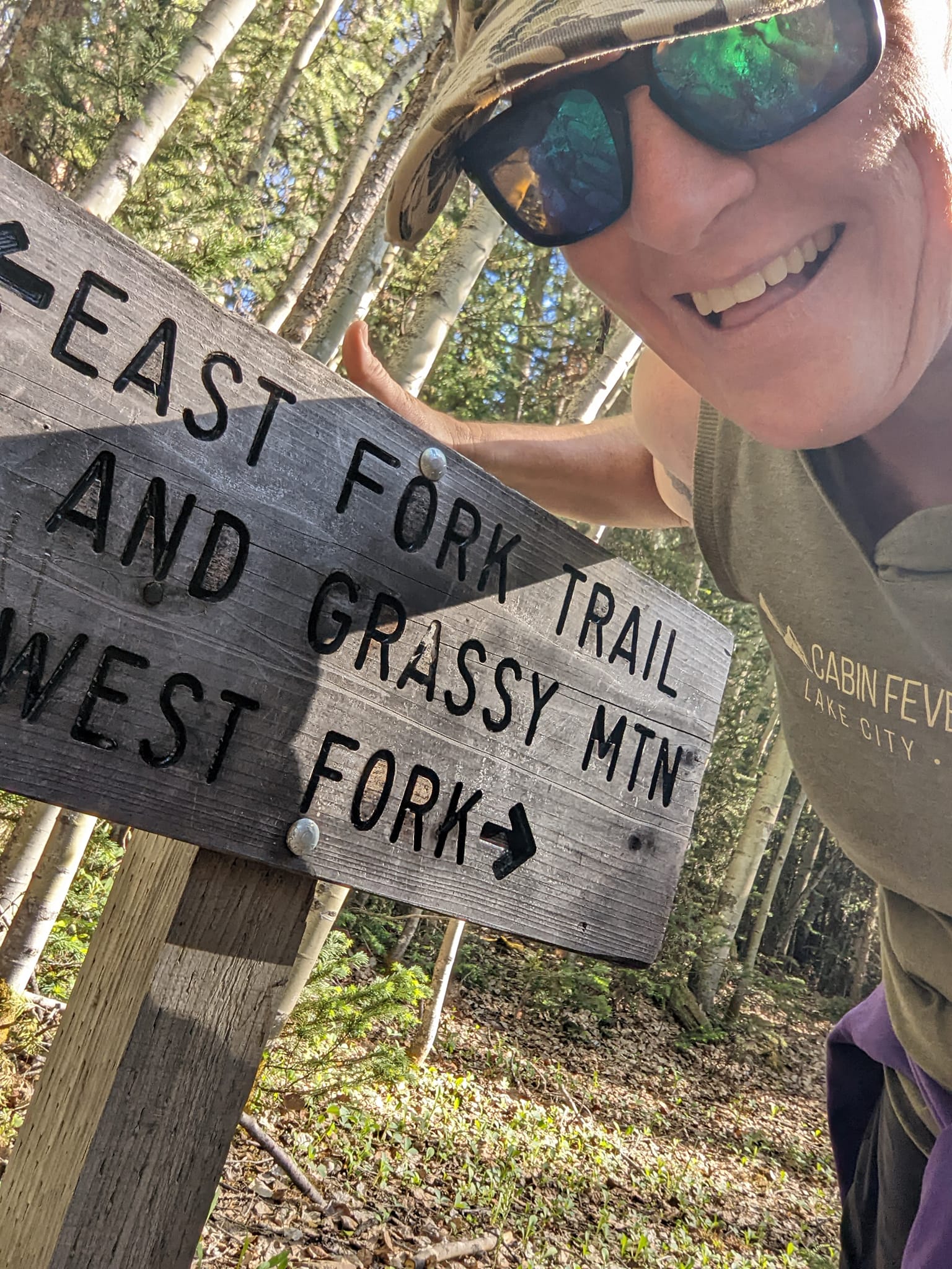 Laurel Darren, owner of Wild Bunch Desert Guides, poses with the sign for Alpine Gulch -- one of the trails offered in the new Colorado hiking tours offered in the expanded services this summer from the Arizona-based Phoenix adventure tours company.