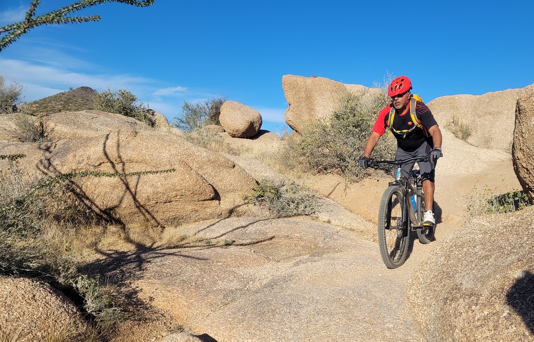 A Wild Bunch guest navigates a rocky downhill during one of our Phoenix mountain bike tours.