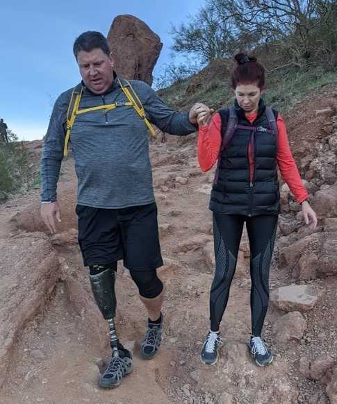 Todd (left) and Tracey Hjerpe (right) are hand-in-hand while making their way down a treacherous portion of Camelback Mountain. After a pair of attempts on a prosthetic leg, Todd successfully summited Phoenix's iconic local landmark in 2019.