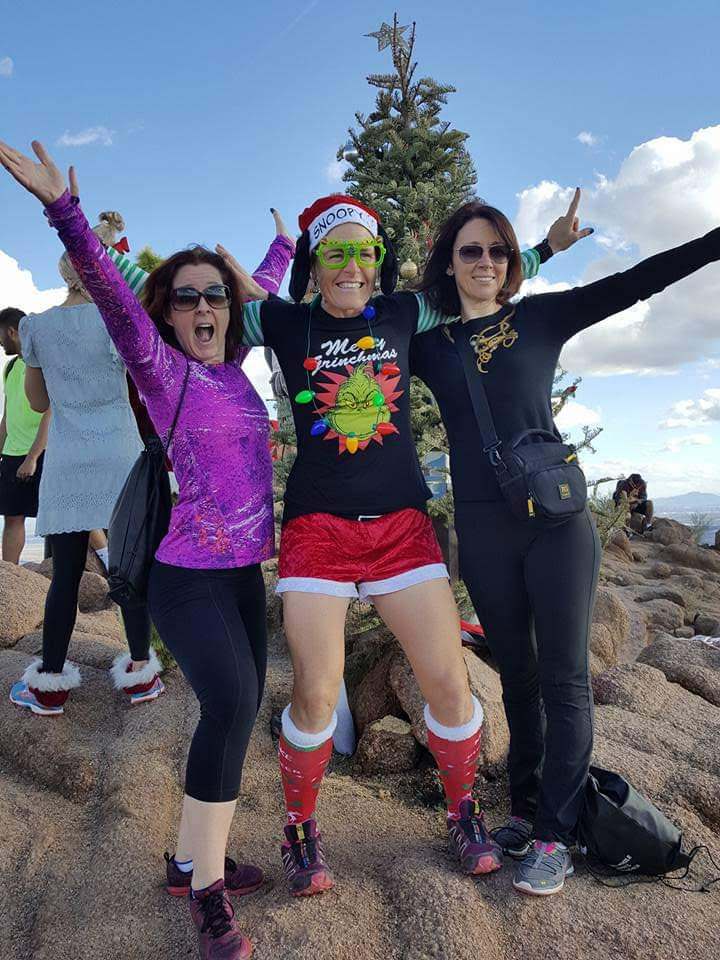 Laurel Darren (center), owner of Wild Bunch Desert Guides, is in a Christmas costume for a holiday hike celebrating with two guests reaching the summit of Camelback Mountain.