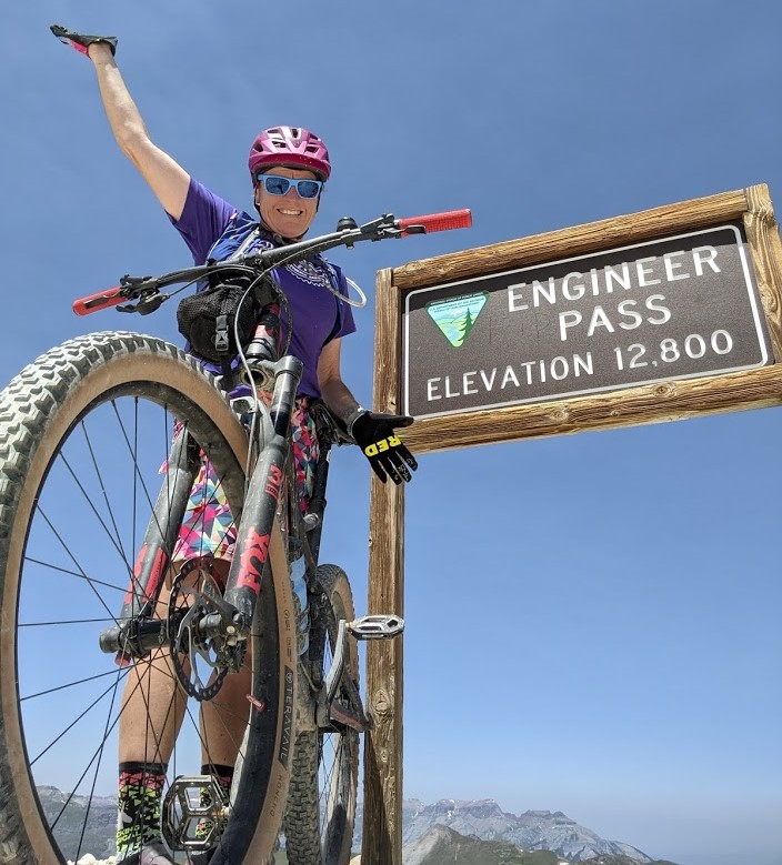 With her right arm raised and trusty mountain bike on her left side, Laurel Darren celebrates reaching the 12,800-foot summit of Engineer Pass in Hinsdale County, Colo. Darren is the owner of Arizona's Wild Bunch Desert Guides, which offers customizable guided Phoenix hiking tours and Scottsdale mountain biking tours.