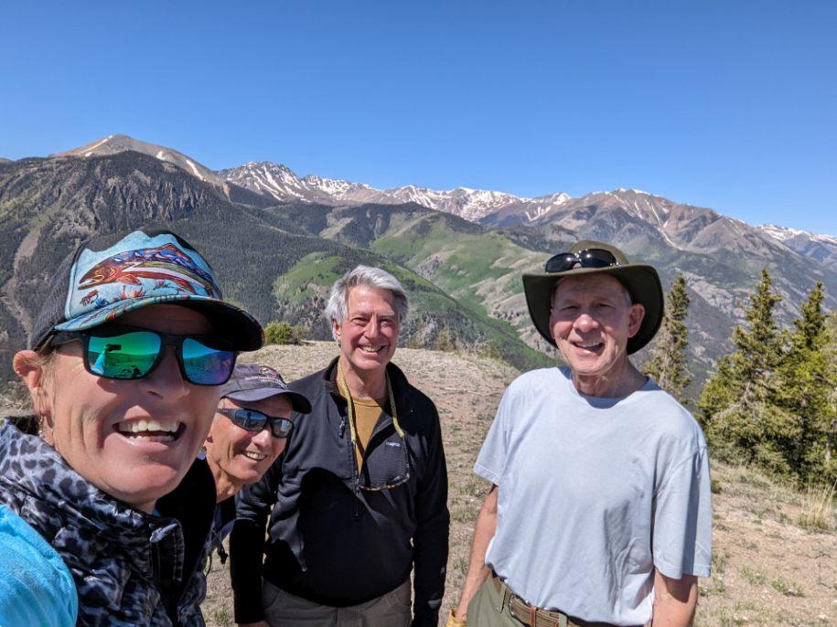 While scouting trails for the upcoming Colorado Hiking Tours offered by Wild Bunch Desert Guides, owner Laurel Darren (left) poses in front of a majestic mountain peak with three members of the Lake City Hiking Club -- (L-R) Glenn Heumann, John Coy and Howard Berg. One of the Lake City area's trademark majestic mountain peaks looms behind the foursome..