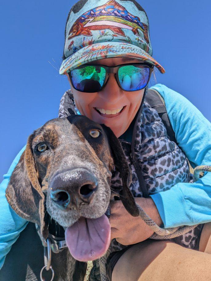 Laurel Darren, owner of Wild Bunch Desert Guides, is all smiles while hiking in Colorado with her Plot Hound, Waylon.