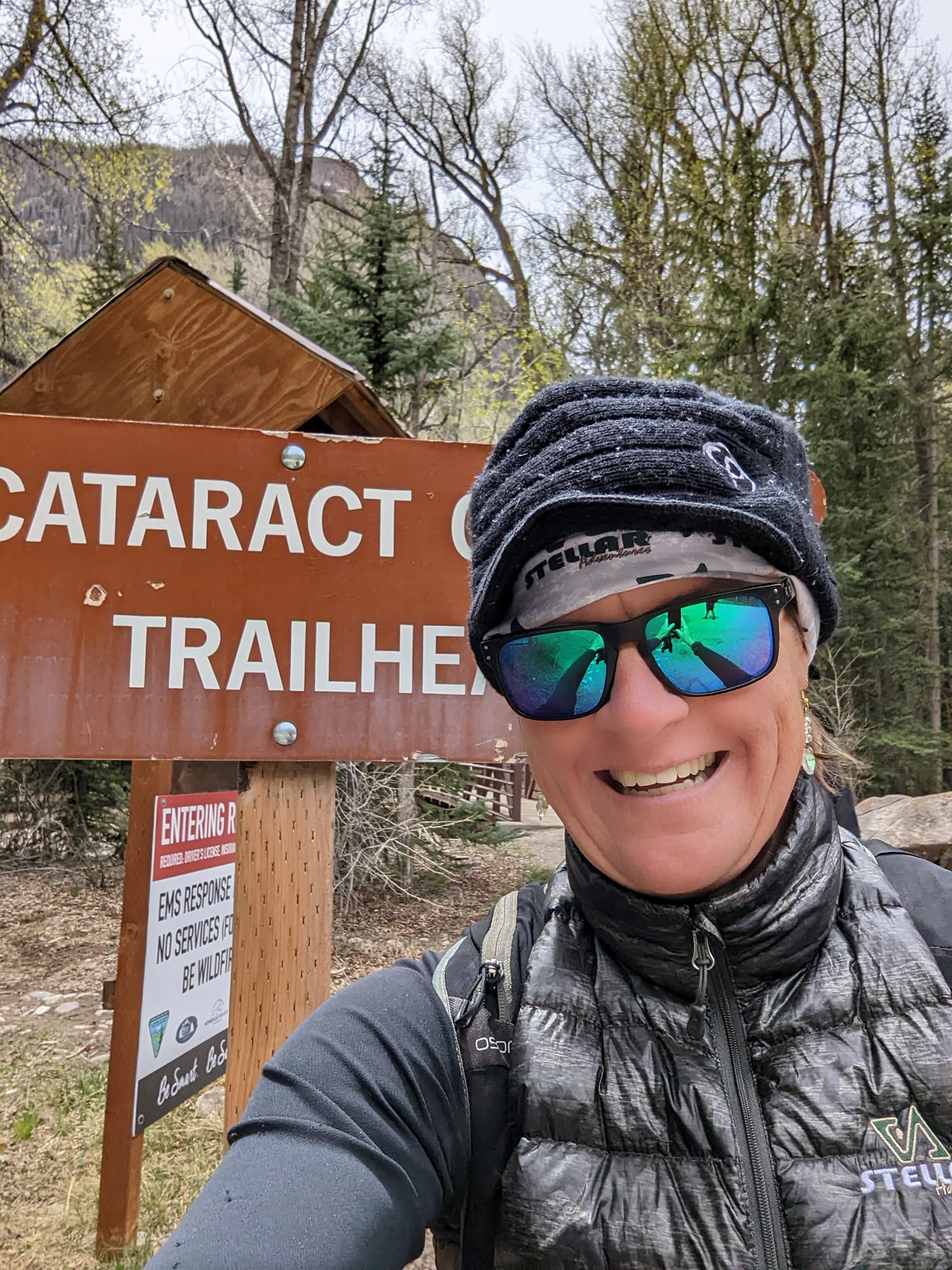 Laurel Darren, founding owner of Wild Bunch Desert Guides, is all smiles standing next to the sign for Cataract Gulch, one of the five new exciting trails offered in the Colorado hiking tours expansion of her small, private, boutique business. 