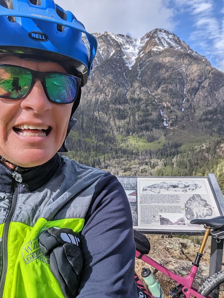 Laurel Darren, owner of Wild Bunch Desert Guides, is all smiles with one of her most popular adventure destinations, Handies Peak, looming behind her.