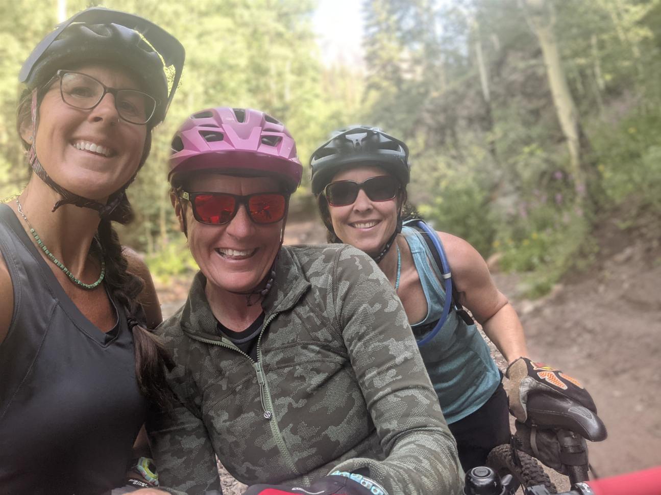 Laurel Darren (center) poses with her Lake City mountain bike pals Amanda Hartman (left) and Lydia McNeese (right) during a training ride this summer. The scenic beauty of Colorado's San Juan Mountains provides an incredible backdrop.