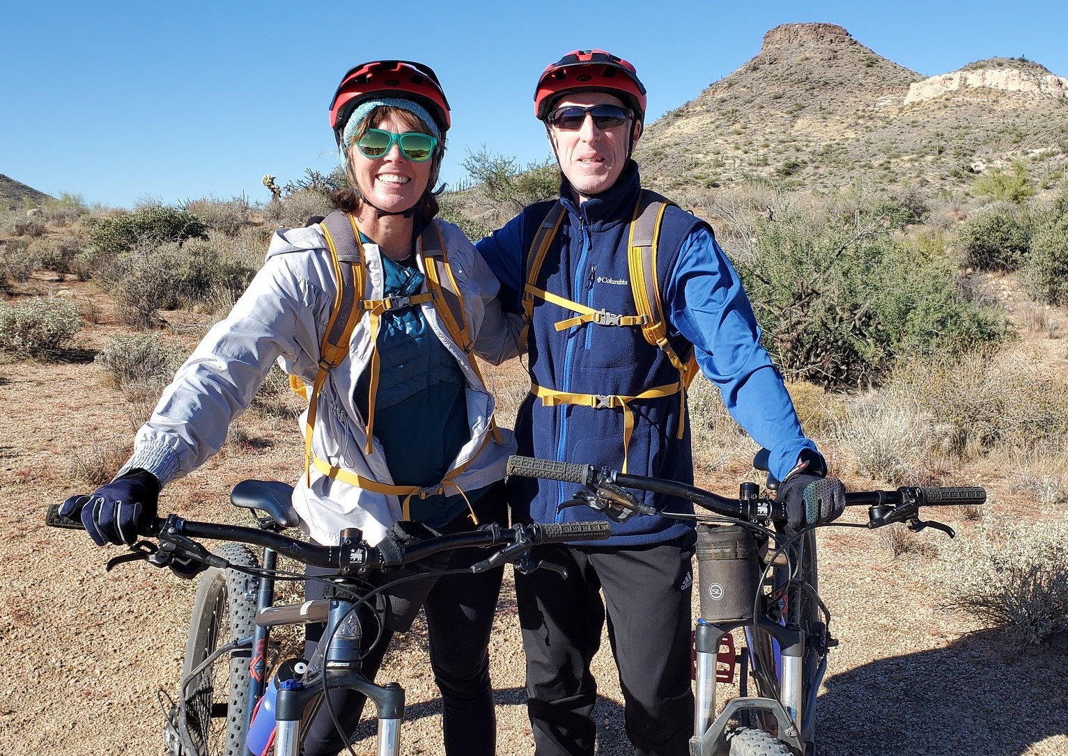 A married couple are all smiles during one of the Scottsdale mountain bike tours from the Wild Bunch Desert Guides. 