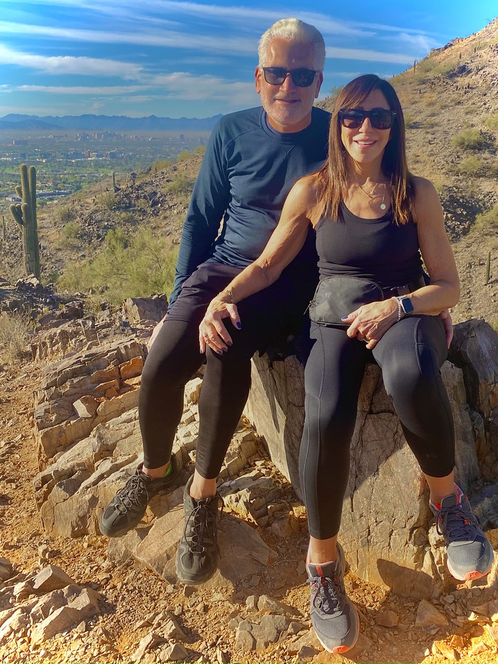 A married couple pauses for a photo with a picturesque Old Southwest backdrop during one of the Phoenix hiking tours from the Wild Bunch Desert Guides.