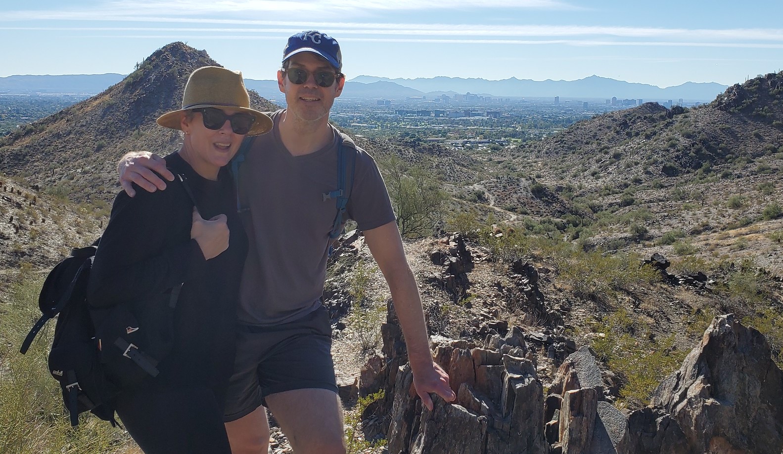 A married couple of hikers pause for a picture in front of a beautiful Sonoran Desert vista during one of the Wild Bunch Desert Guides adventure tours Phoenix/Scottsdale. 