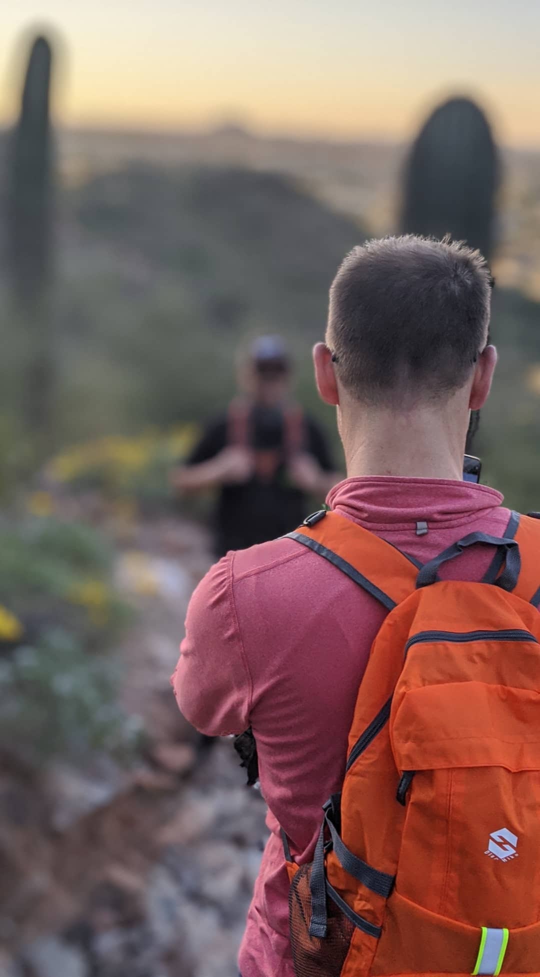 A hiker listens intently to his Wild Bunch guide during a group hike on a particularly majestic Phoenix hiking trail.