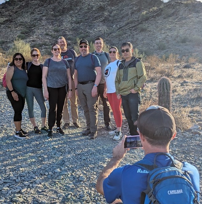 A group of friends sharing a Phoenix hiking tours adventure together with the Wild Bunch pauses to take a memorable vacation photo in the Sonoran Desert.