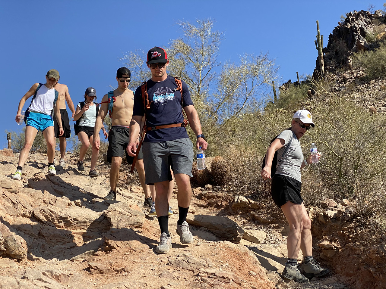 A group of six hikers make their way down a rocky hillside during a Wild Bunch Desert Guides summer adventure.