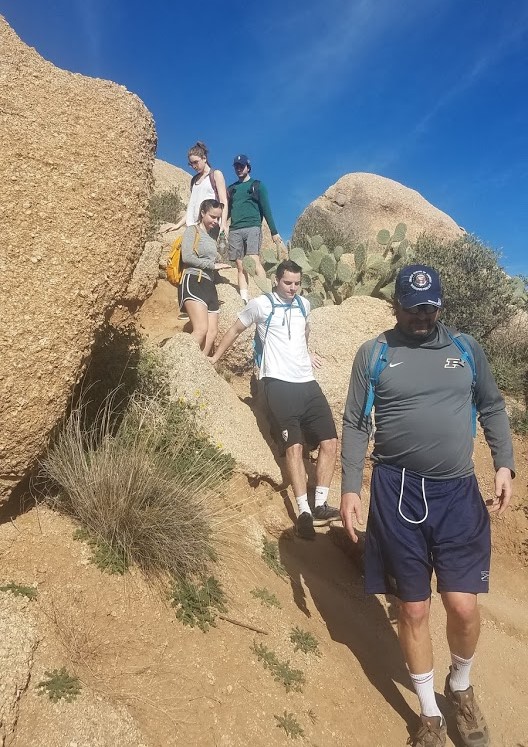 A group of five hikers descends a rock formation during one of the Wild Bunch's recent guided Phoenix hiking tours.