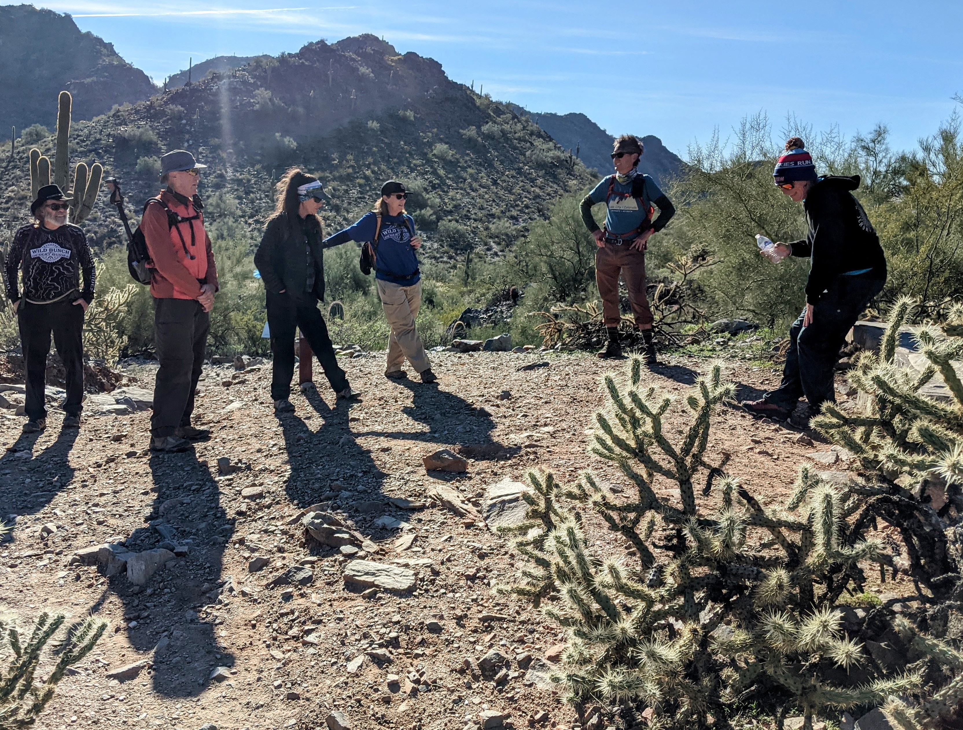 Surrounded by cactus and a mountainous backdrop, Henry's hiking group takes a break in the sun on one of the Wild Bunch's Phoenix hiking tours.