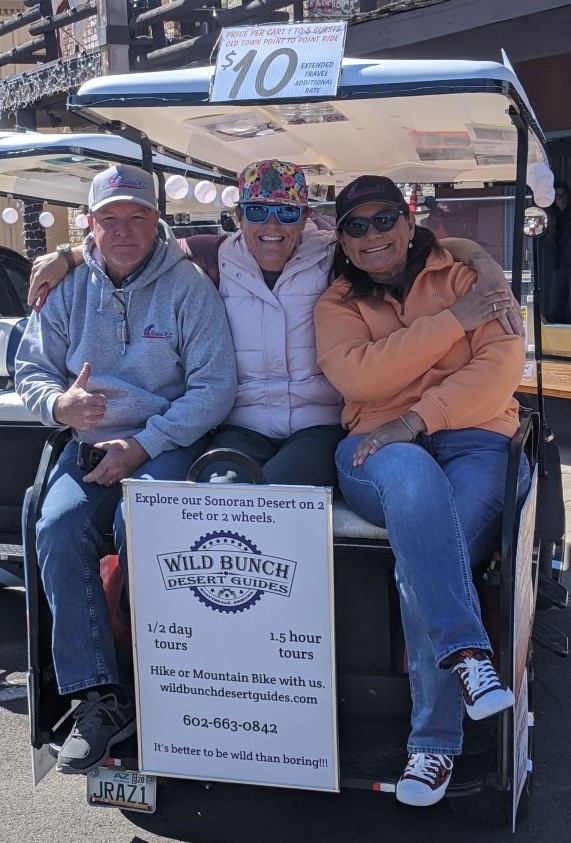 Wild Bunch Desert Guides owner Laurel Darren (center) enjoys a golf cart ride in Old Town Scottsdale with JoyridesAz.