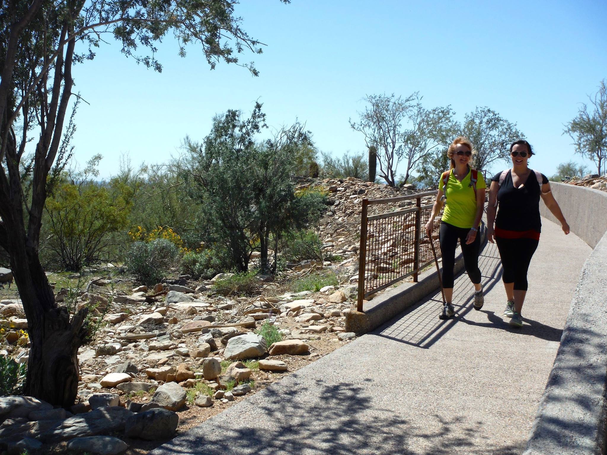 Courtesy of the McDowell Sonoran Preserve Conservancy, two women enjoy the completely accessible beauty of the trees and desert vegetation during a hike along the paved path of the Kovach Family Nature Trail at the Lost Dog Wash Trailhead.