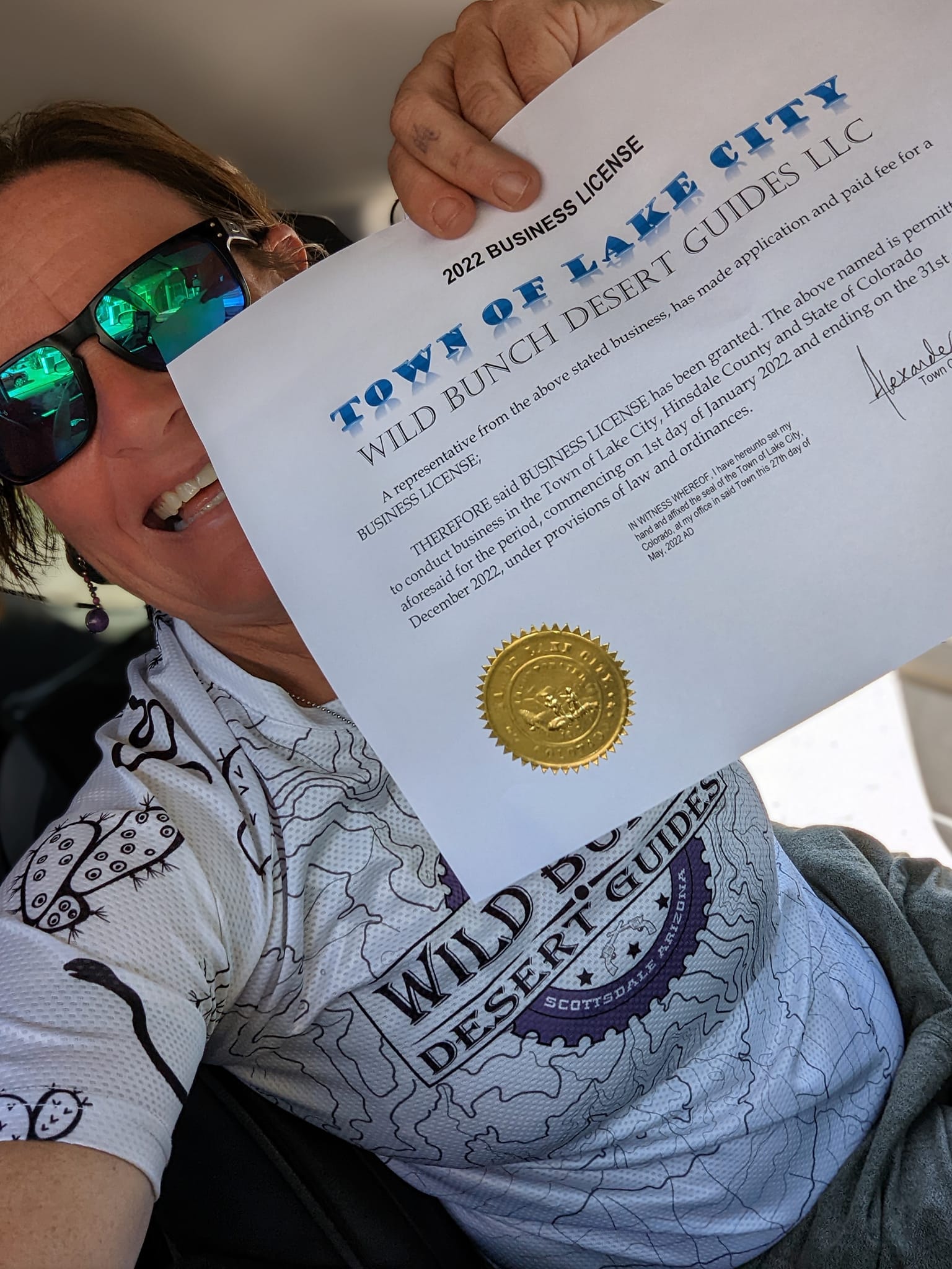 Wild Bunch Desert Guides owner Laurel Darren shows off her new business license from Lake City, Colorado. Wild Bunch is expanding from its Phoenix adventure tours roots to offering Colorado hiking tours this summer in the remote tourist destination of the Lake City region in the San Juan Mountains.. 