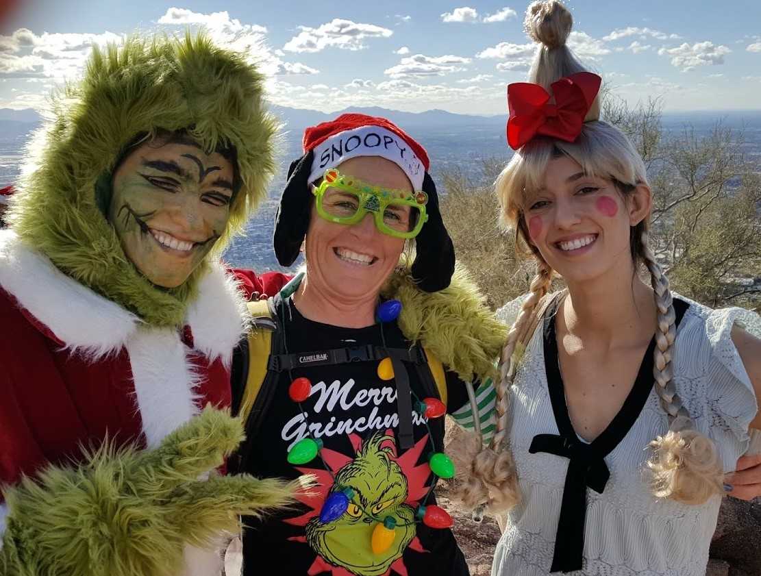 Laurel Darren, owner of Wild Bunch Desert Guides, joins a couple of other costume-wearing hikers celebrating Christmas atop Camelback Mountain. 