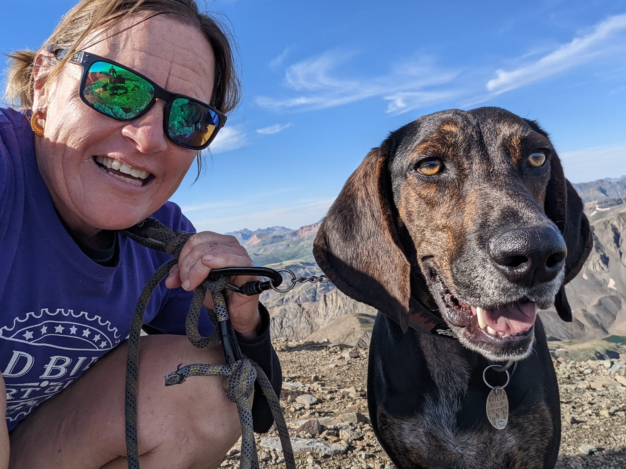 Laurel Darren, Wild Bunch Desert Guides owner, is all smiles while posing with her Plott Hound Waylon on the summit of Handies Peak.
