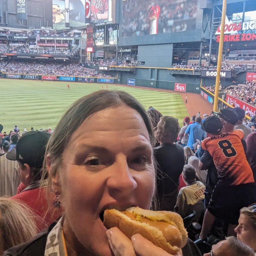 Wild Bunch owner Laurel Darren enjoys a hot dog during Game 3 of the 2023 World Series.