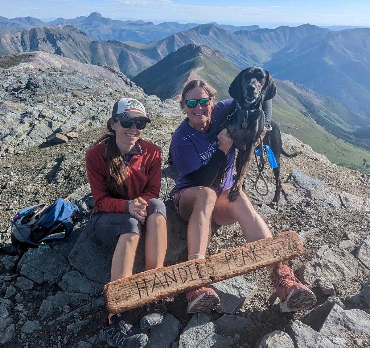 Laurel Darren (center) is flanked by Lydia and Laurel's Plott Hound Waylon while posing atop Colorado's Handies Peak.
