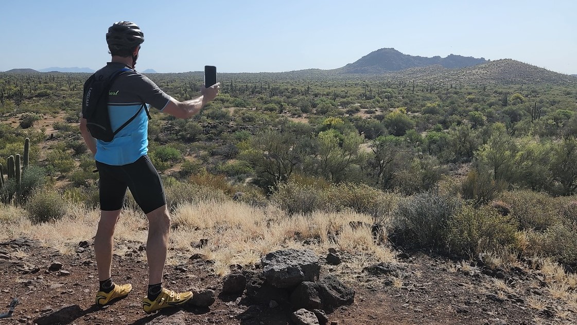 A solo cyclist takes a cellphone picture of a panoramic view from the Sonoran Desert floor during a Phoenix adventure tour with the Wild Bunch Desert Guides. The small mom-and-pop specialty shop offers corporate and group outings -- but only up to a point -- but is better suited to serve the needs of individuals, couples and families.