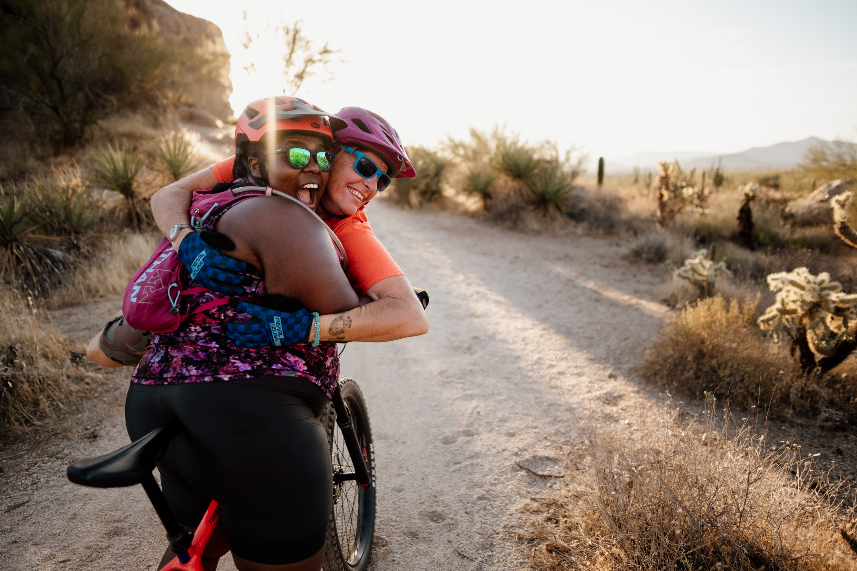 Mirna Valerio (left) and her friend Laurel Darren share a huge hug together during a Scottsdale mountain biking adventure in the Sonoran Desert.