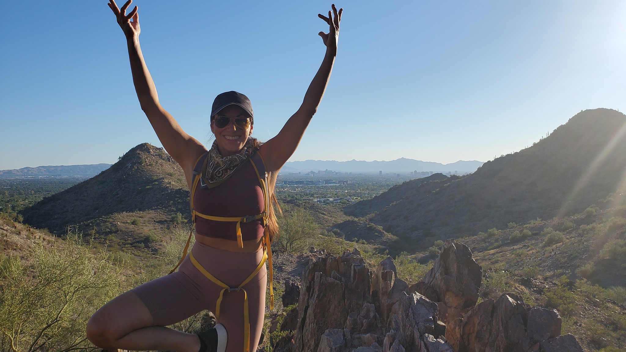 A female guest can hardly contain her joy while posing for this picture in front of an incredible vista during a Phoenix hiking tour with girl friends from the Wild Bunch Desert Guides.