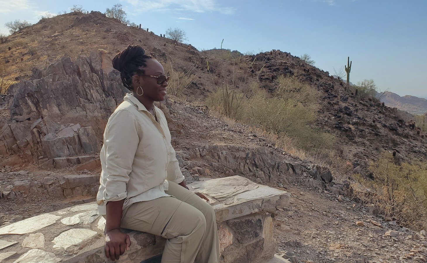 While taking a break on a bench during one of the Phoenix hiking tours from the Wild Bunch Desert Guides, a woman has time for private contemplation while enjoying another unforgettable view of the Sonoran Desert.