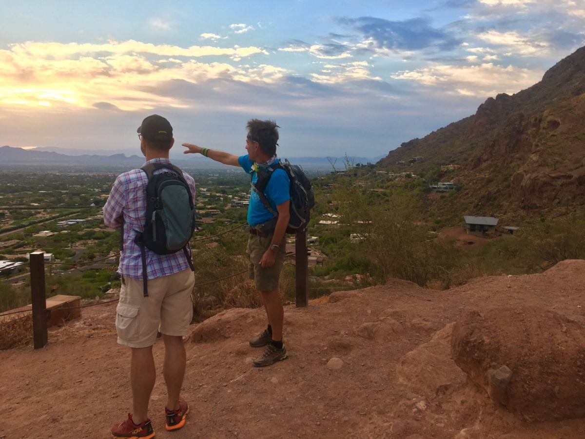 A guide points out several landmarks to a guest while they enjoy the amazing vistas together during a Wild Bunch Desert Guides adventure tour.