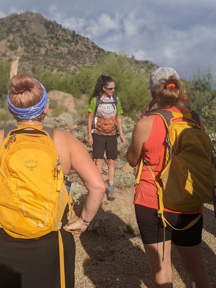Lead guide Rebel (center) explains a portion of the Sonoran Desert while surrounded by a circle of Veterans during one of the Phoenix hiking tours from the Wild Bunch Desert Guides.