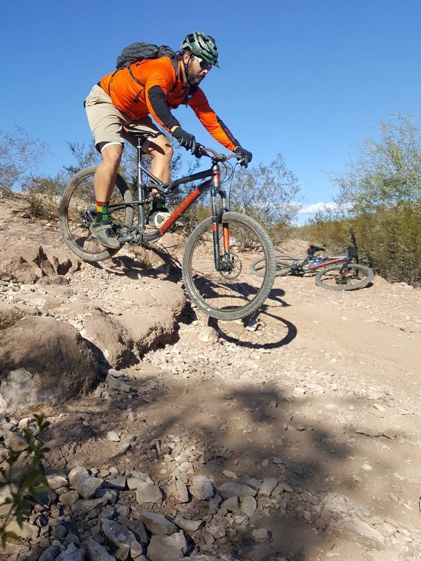 A Phoenix mountain bike tours participant rides over a rough patch on the trail during an adventure with the Wild Bunch.