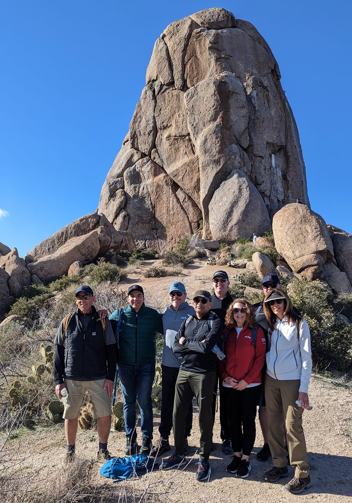 A Phoenix hiking tours group pauses in front of one of the iconic rock formations in the Sonoran Desert during a Wild Bunch adventure.