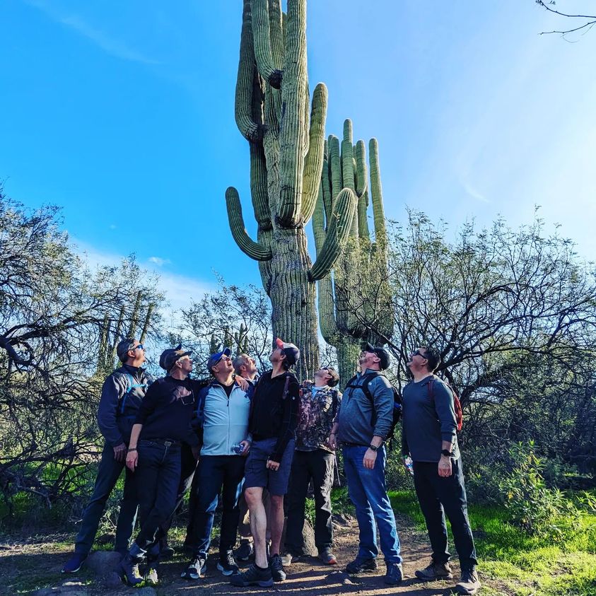 A Phoenix hiking tours group looks impressed by a Saguaro Cactus during a Wild Bunch Desert Guides adventure. 