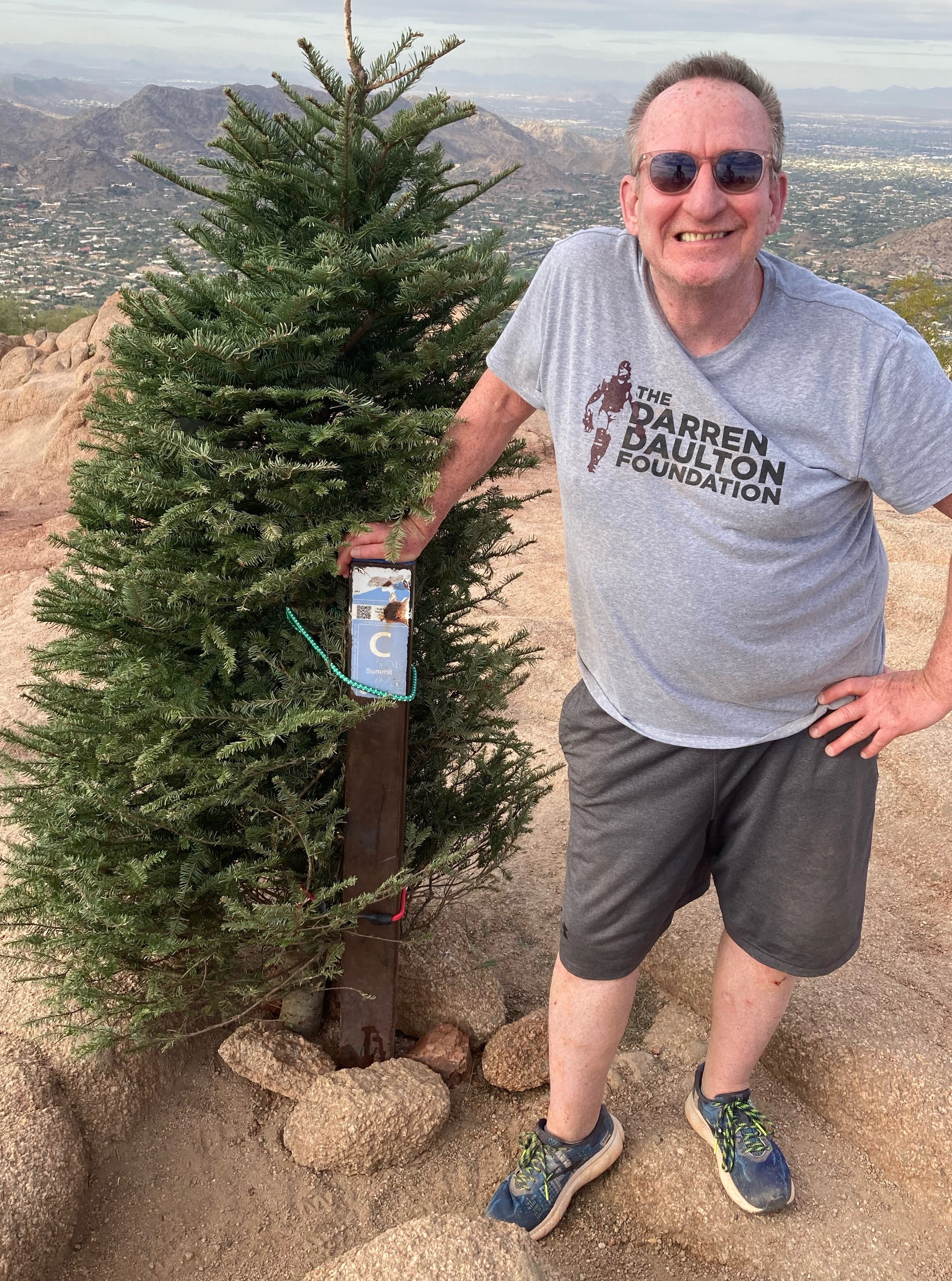 John Duffin poses in front of the Camelback Christmas tree on the summit of the iconic Phoenix landmark.