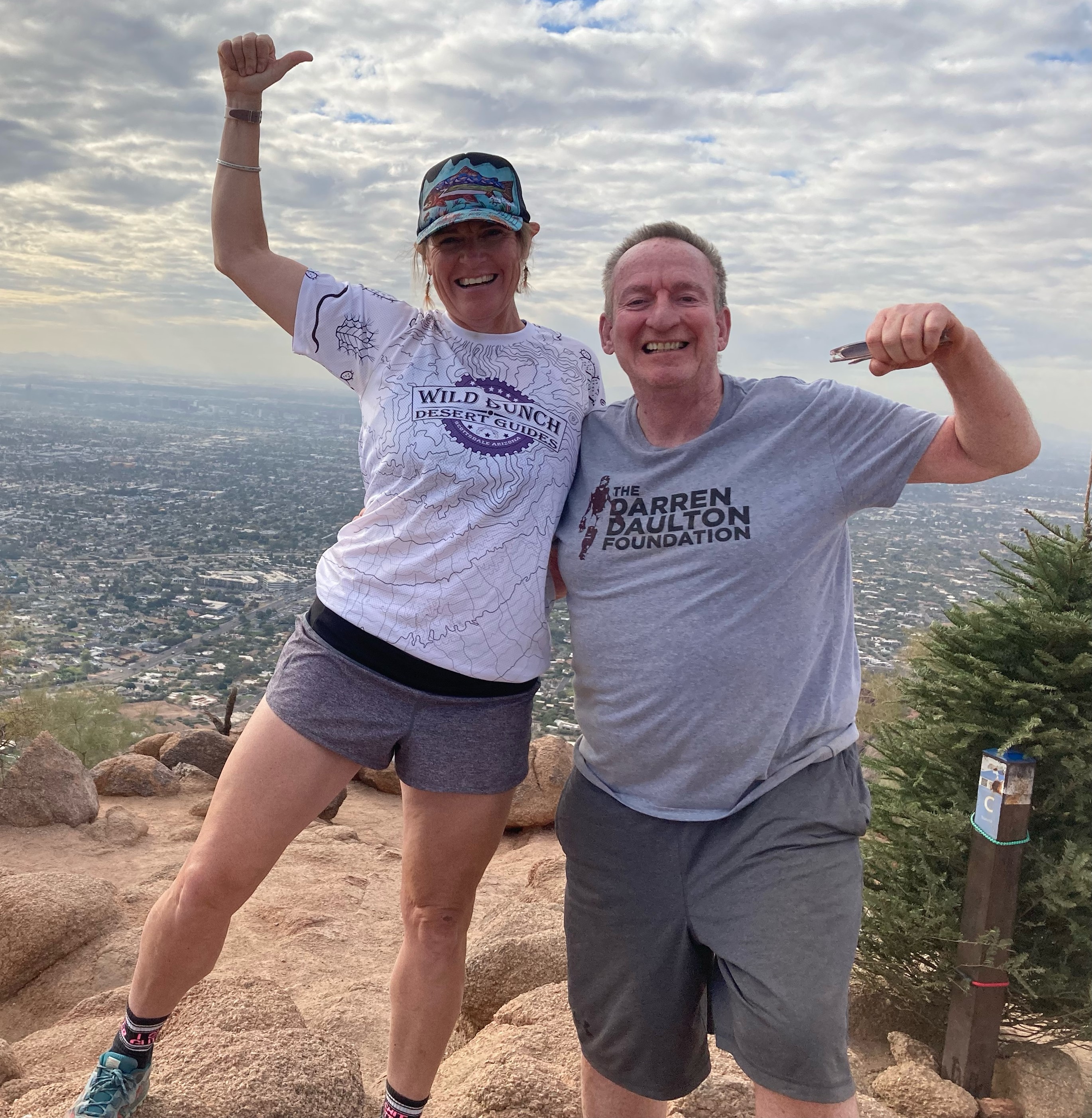 Laurel Darren (left), the Wild Bunch Desert Guides owner, celebrates reaching the summit of Phoenix's iconic Camelback Mountain with first-time guest John Duffin. The panoramic views of Phoenix serve as their beautiful backdrop.