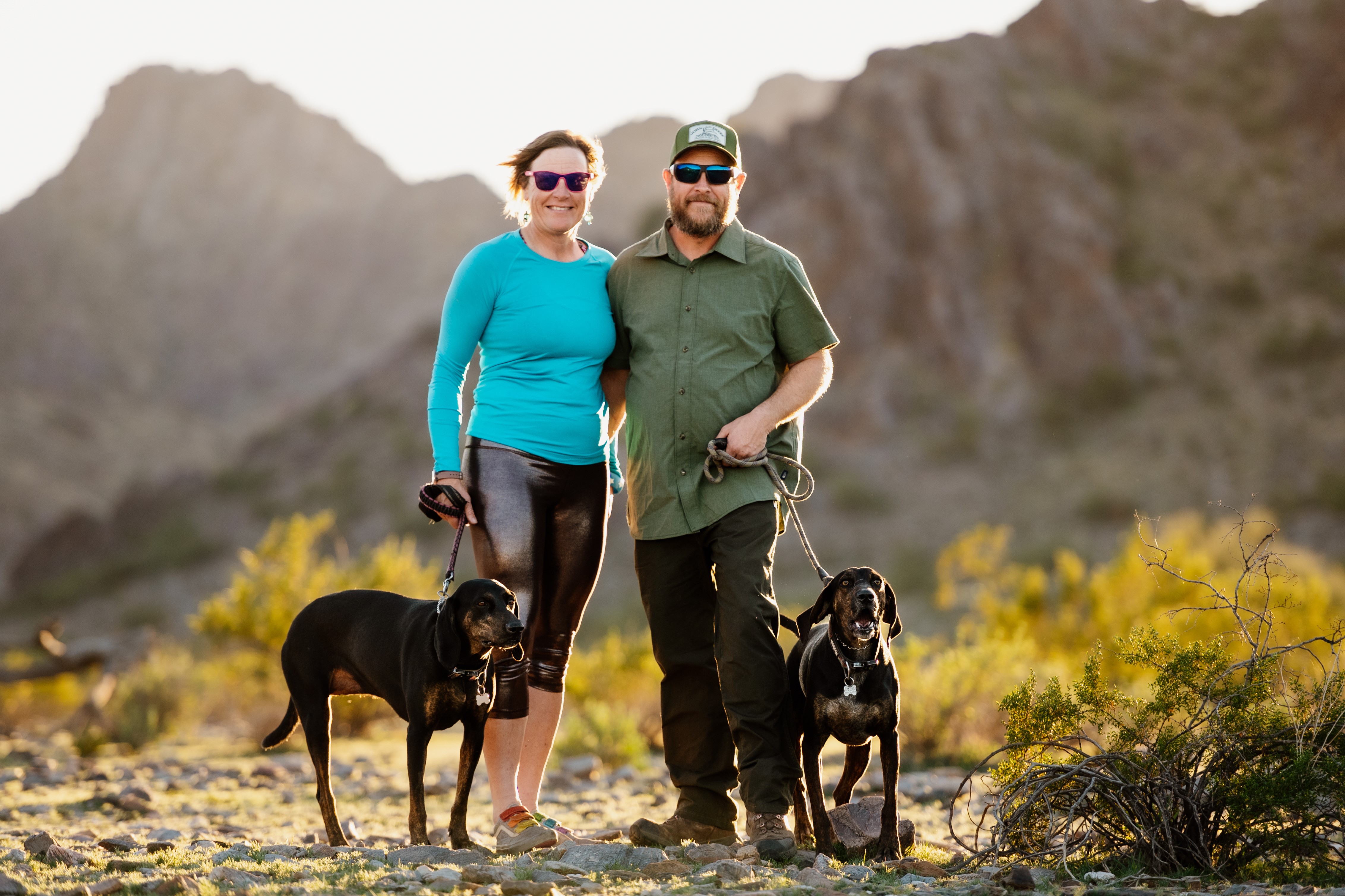 A final family photo before Daisy Mae was euthanized. Laurel (left) with Daisy Mae and Brett (right) with Waylon pose in front of a picturesque Sonoran Desert background,